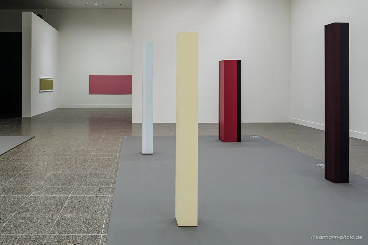 Moderne Kunstinstallation mit bunten Säulen in einer Galerie