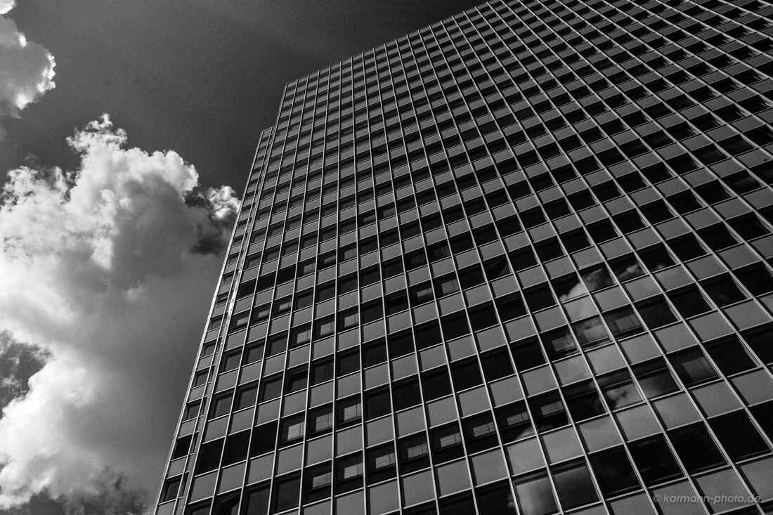 Modernes Hochhaus mit Spiegelung von Wolken im Glas
